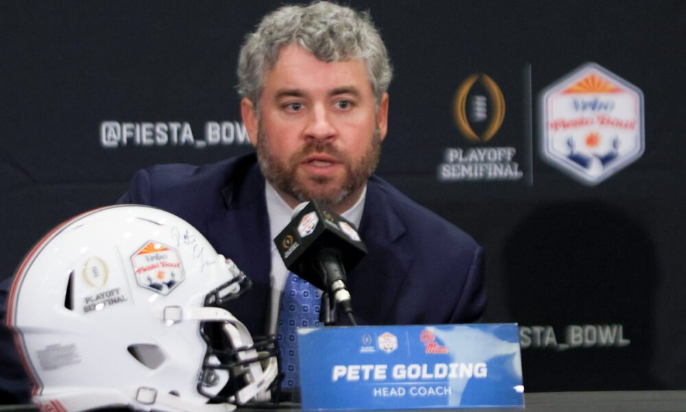 Ole Miss Rebels coach Pete Golding on the stage at a press conference with Miami Hurricanes coach Mario Cristobal