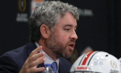 Ole Miss Rebels coach Pete Golding on the stage at a press conference with Miami Hurricanes coach Mario Cristobal