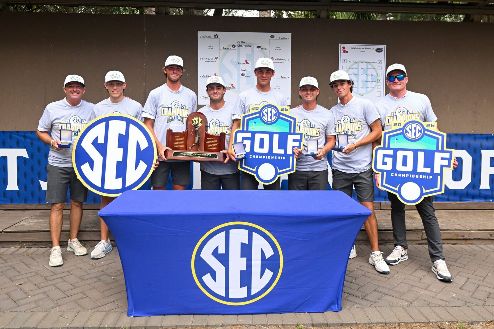 Ole Miss men's golf team poses for photos with the 2026 SEC championship trophy and medals. | Ole Miss Athletics
