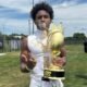 Port Charlotte (Fla.) wide receiver poses with a 7-on-7 championship trophy from The Crown 2026 National Championship. | Elias Pearl/X